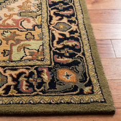 the rug is on the wooden floor and has an animal motif in green, blue, yellow, orange and brown colors