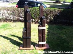 three pieces of wood sitting on top of a green field next to a black car