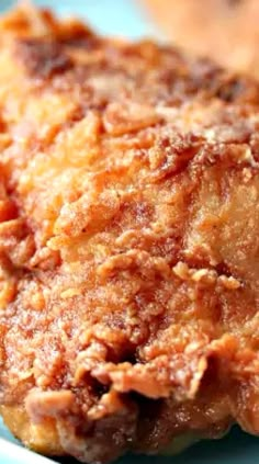 fried chicken on a blue plate with some bread in the backgroung area