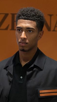 a man in a black shirt is looking at the camera with an intense look on his face