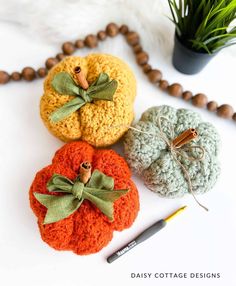 three crocheted pumpkins sitting on top of a table