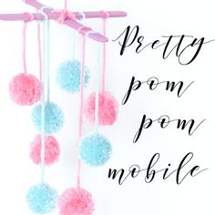 pink and blue pom - pom mobile hanging from a string with the words pretty pom - pom mobile on it