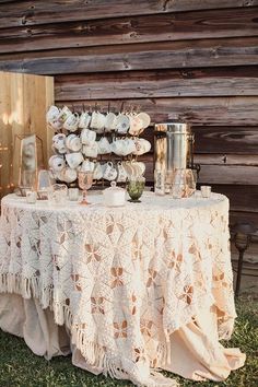 a table topped with white flowers next to a wooden wall