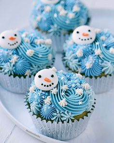 cupcakes decorated with frosting and snowmen on a plate