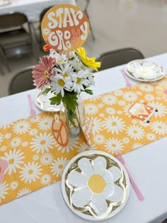 a table set with plates, flowers and napkins for a graduation party or celebration