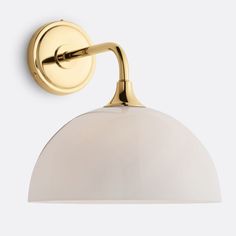 an image of a white light fixture on the side of a wall with a gold finish