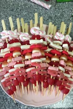 a plate topped with marshmallows and pretzels on skewers