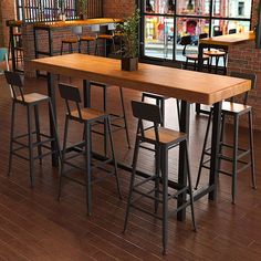 an empty restaurant with tables and stools in front of a window that has a view of the street