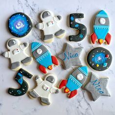 decorated cookies are arranged in the shape of rocket ship, space shuttle and rocketship