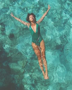 a woman is floating in the clear blue water