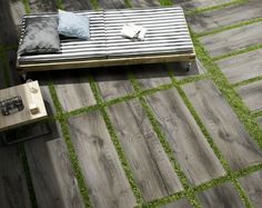 a bed sitting on top of a wooden floor next to a green grass covered field