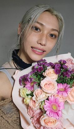 a woman holding a bouquet of pink and white flowers