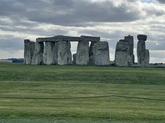 the stonehenge monument in england is surrounded by lush green grass and cloudy skies