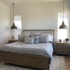 a bedroom with a bed and two lamps hanging from the ceiling