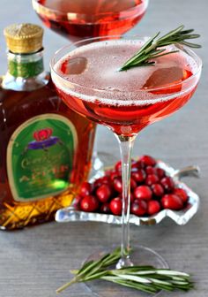 two glasses filled with liquid and garnished with rosemary