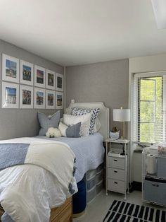 a bed room with a neatly made bed and pictures on the wall