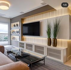 a living room with a large flat screen tv mounted on the wall next to a coffee table