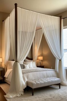 a bedroom with four poster bed and white drapes