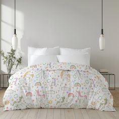 a bed with unicorns and stars on it in a room next to two lamps