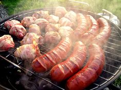 hot dogs and sausages cooking on the grill