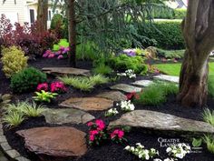 a screen shot of a garden with flowers and rocks in the foreground, along with an image of a tree