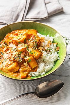 a green bowl filled with rice and curry