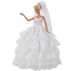 a barbie doll wearing a white wedding dress and veil with her hand in the air