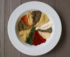 a white bowl filled with spices on top of a wooden table