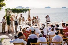 a group of people standing on top of a beach next to each other under umbrellas