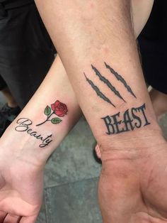 two people holding hands with tattoos on their arms and the words beast, beauty and roses