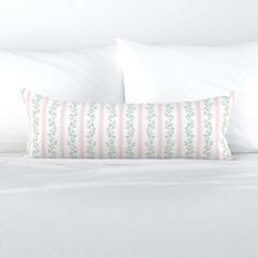 a bed with white sheets and pink striped pillows on top of it, next to a pillow case