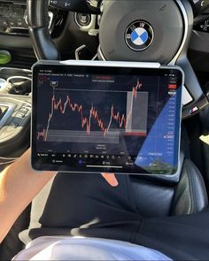 a person holding up a tablet in their car