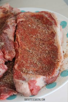 two pieces of meat on a plate with seasoning sprinkled over them and sitting next to each other