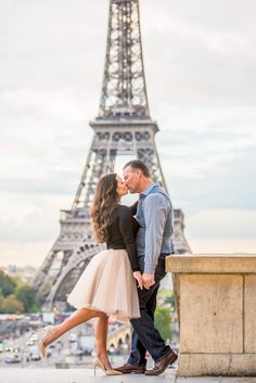 a couple kissing in front of the eiffel tower