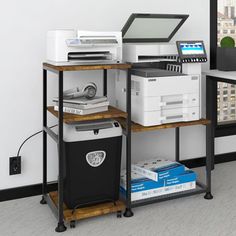 there is a computer and printer on the shelf next to each other in this room