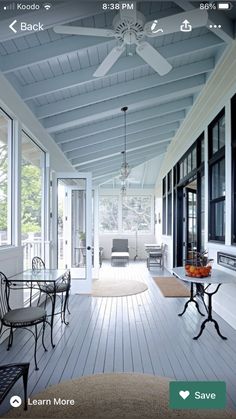 an open porch with white walls and ceiling fan on the ceiling is seen in this image