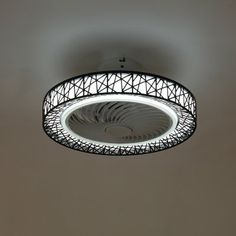 a circular light fixture in a room with white walls and ceiling lights on the ceiling