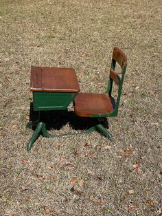 an old school desk and chair sitting in the grass