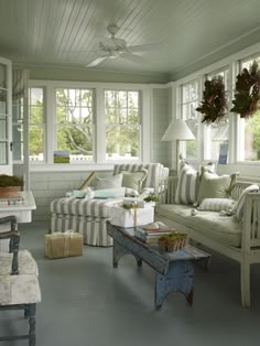 a living room filled with furniture and windows covered in striped pillows on top of them