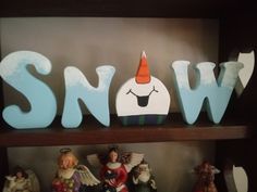 a shelf filled with figurines and snow letters