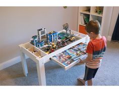 a young boy playing with legos on a table in the living room at home