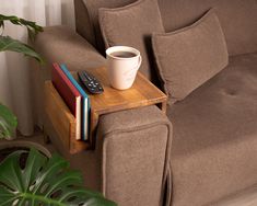 a coffee cup sitting on top of a table next to a remote control and books