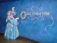 there is a statue on display in front of a blue wall with the words once upon it