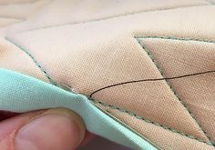 someone is stitching on the side of a piece of fabric