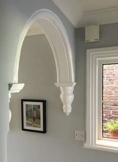 a white toilet sitting under a window next to a wall mounted air freshener dispenser