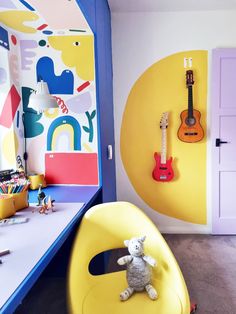 a child's room with a yellow chair and guitar wallpaper on the walls