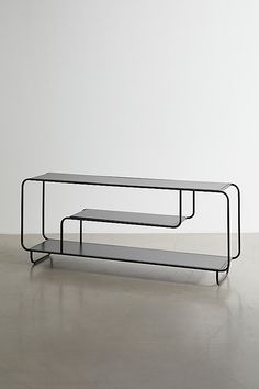 two tables sitting on top of each other in front of a white wall and floor