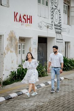 a man and woman are walking down the street