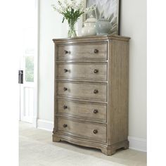 a wooden dresser with flowers on top of it