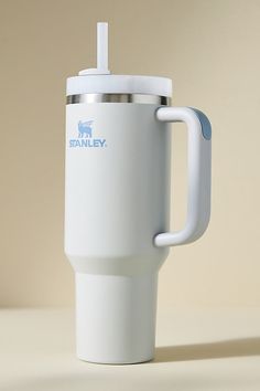 a white travel mug with a handle on it